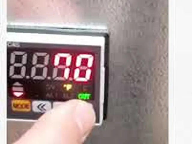 Finger on a PRIMO digital temperature controller (frame from the WaxMelters video)